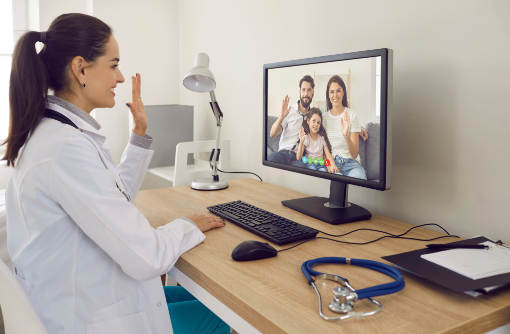 Picture of a doctor in a online telehealth meeting with a family 
